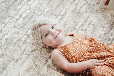 Cute baby laying on stylish baby foam play mat by Famokids